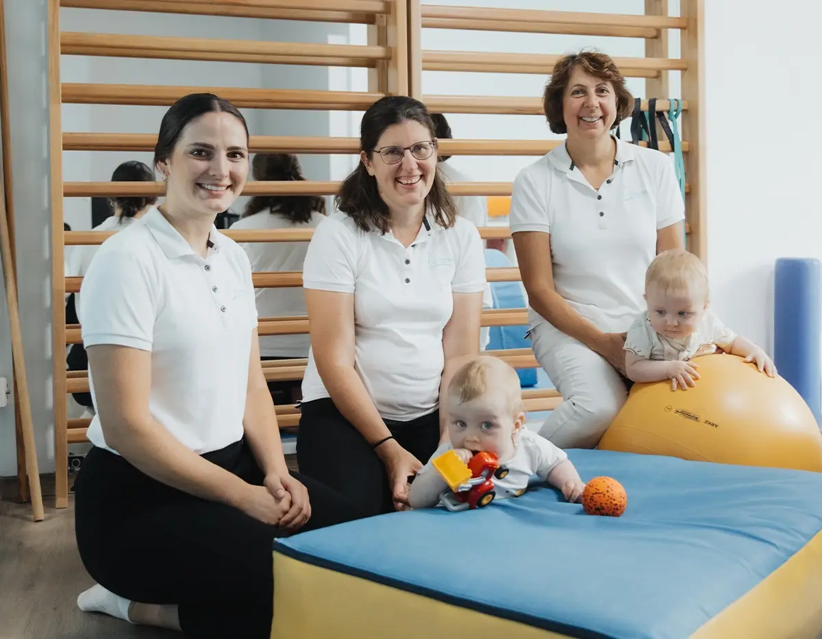 Drei Physiotherapeutinnen von Eden Physiotherapie München beim Training mit zwei Kindern im Bewegungsraum